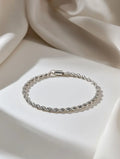 Silver bracelet on a soft beige fabric background