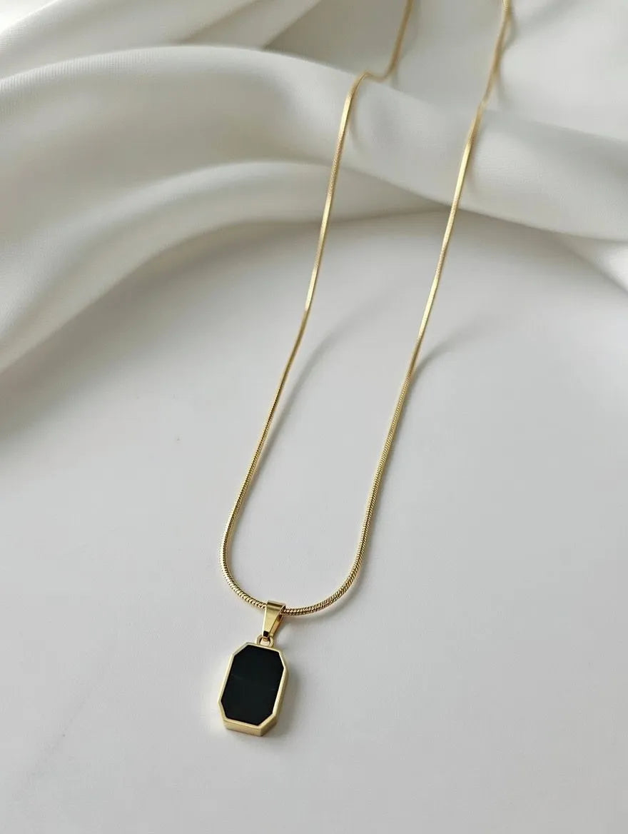 Unisex gold-toned circular pendant with engraved