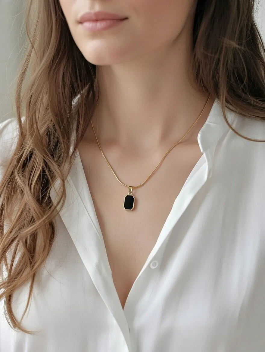 Unisex gold-toned circular pendant with engraved