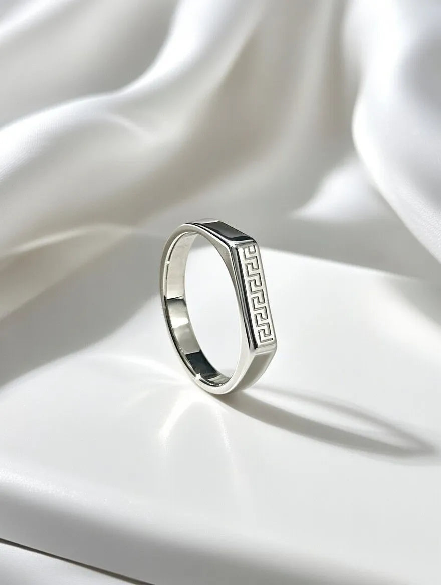 A polished gold men's signet ring with a rectangular silver-toned face