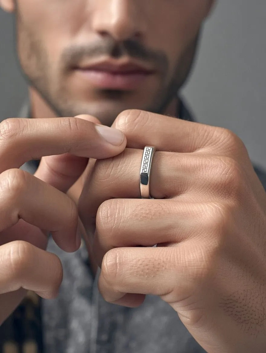 A polished gold men's signet ring with a rectangular silver-toned face