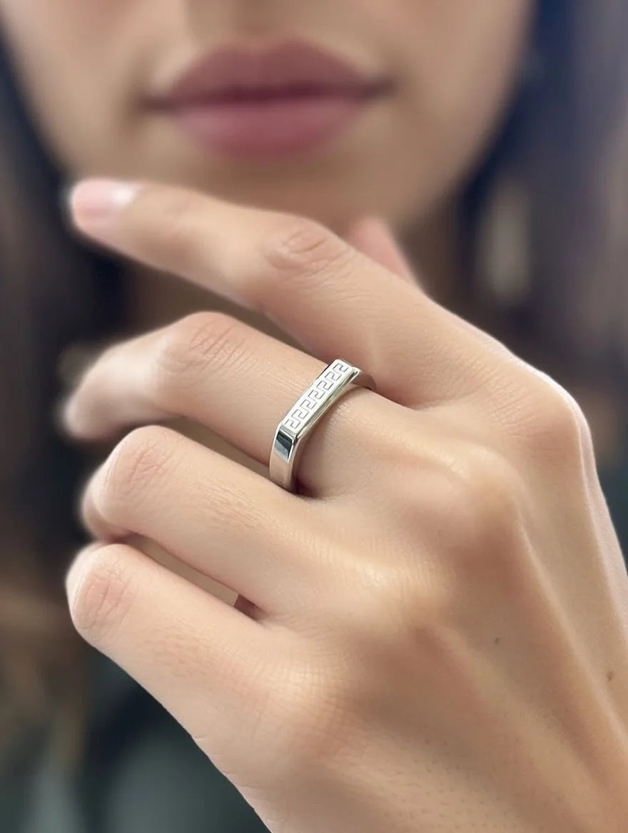 A polished gold men's signet ring with a rectangular silver-toned face