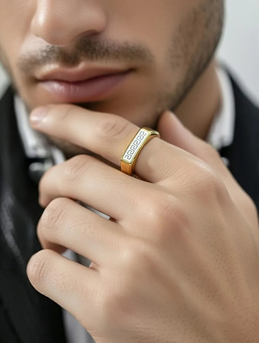 A polished gold men's signet ring with a rectangular silver-toned face