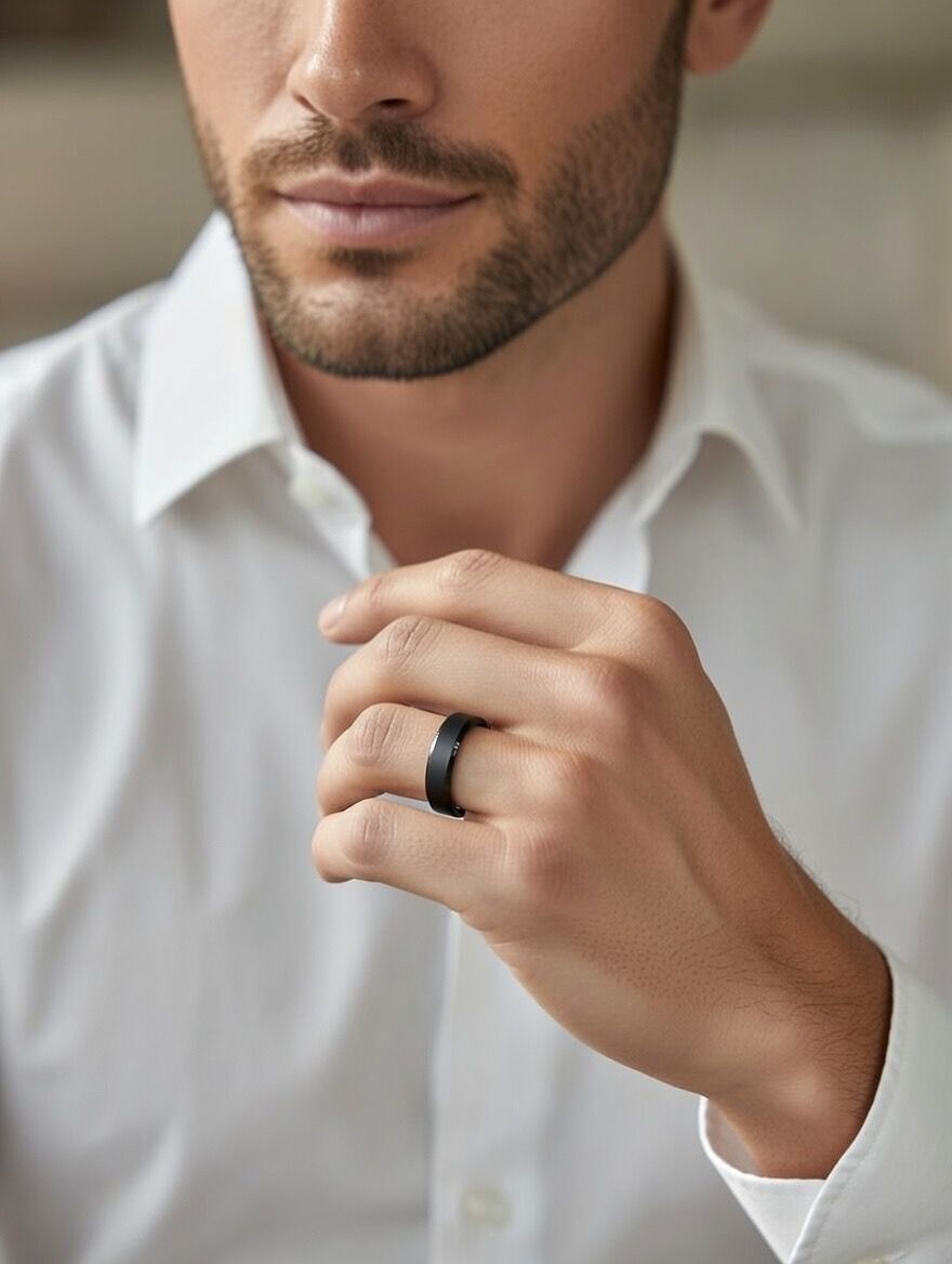 A men's minimalist band ring with a smooth matte black finish