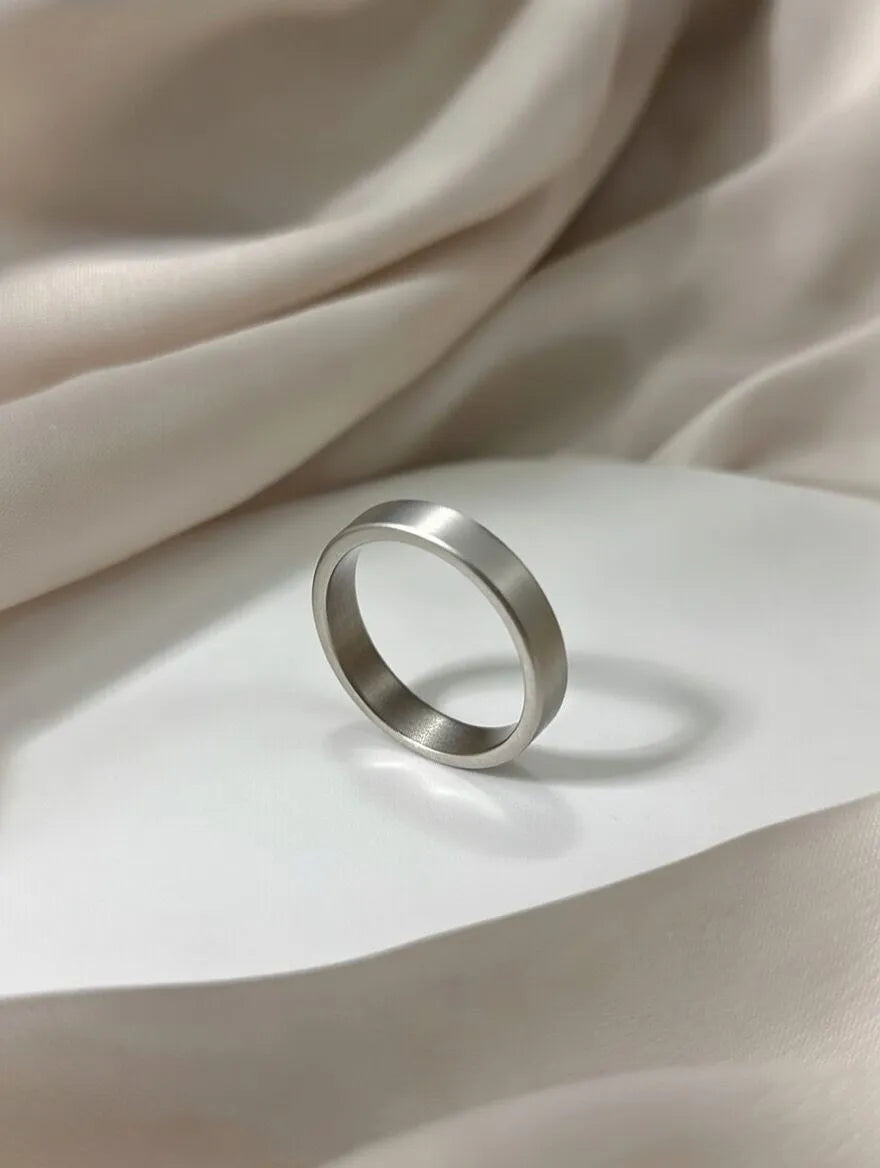 A minimalist men's ring with a matte silver brushed finish