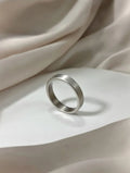 A minimalist men's ring with a matte silver brushed finish