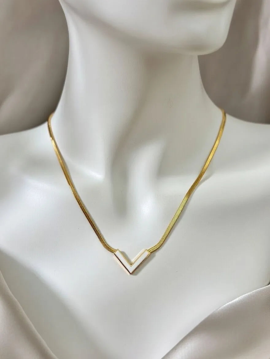 Gold necklace on a mannequin with a plain background