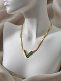 A gold-toned flat snake chain necklace with a V-shaped