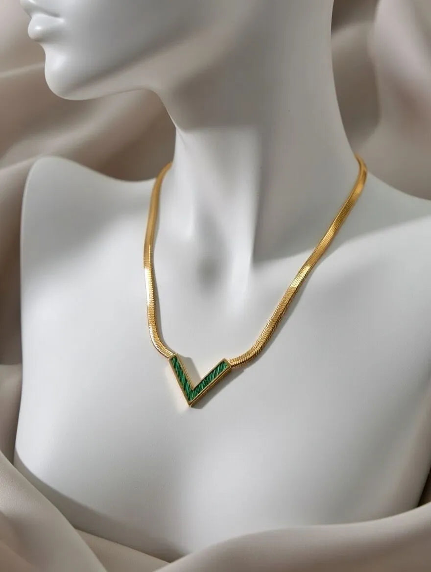A gold-toned flat snake chain necklace with a V-shaped