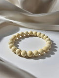 Unisex stretch bracelet featuring smooth cream-colored round beads